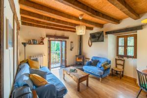 a living room with a blue couch and a table at Casa Monaut, acogedores apartamentos a los pies de la selva de Irati in Saragüeta