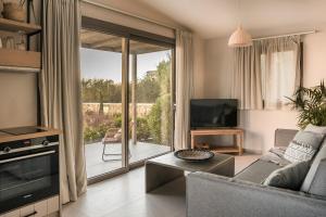 a living room with a couch and a sliding glass door at Ammos Suite-Grand Blue Beach Residence in Lixouri