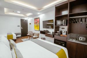 a hotel room with a bed and a kitchen at ASN Boutique Residence in Manila