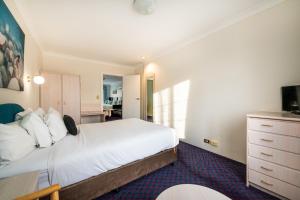 um quarto de hotel com uma cama e uma televisão em Golden Age Motor Inn em Queanbeyan