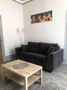 a living room with a black couch and a coffee table at Haussemannien in Nevers +9 photos