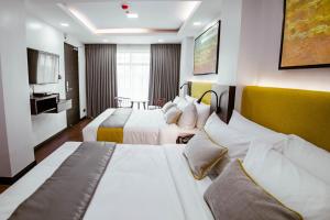 a hotel room with two beds and a television at ASN Boutique Residence in Manila