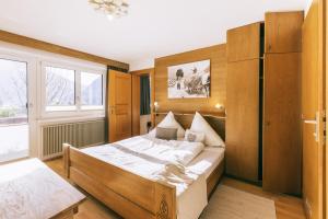 sypialnia z dużym łóżkiem i dużym oknem w obiekcie Landhaus Perktold w mieście Nesselwängle
