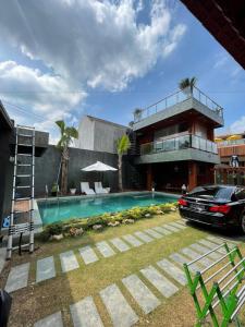 a car parked in front of a house with a swimming pool at Villa SB Pacet in Sajen