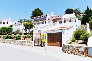 a white house with a gate on a street at VILLA MARIA vistas al mar y piscina privada in Son Bou