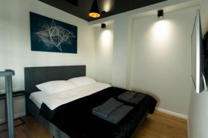 - une chambre avec un lit aux murs blancs et une photo dans l'établissement Loft Apartament Patio Vita- Klimatyzacja Garaż podziemny, à Kielce