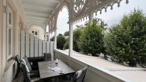 a porch with a table and chairs on a balcony at Villa Sonneck - Wohnung 7 in Ostseebad Sellin +43 photos