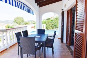 stół i krzesła na balkonie z basenem w obiekcie VILLA MARIA vistas al mar y piscina privada w Son Bou