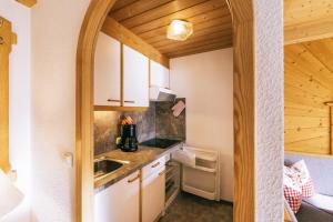 a small kitchen with white cabinets and a sink at Landhaus Perktold in Nesselwängle