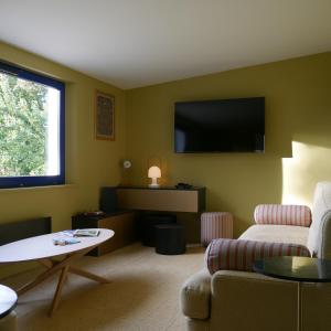 a living room with a couch and a flat screen tv at Maison HOUX in Dominois