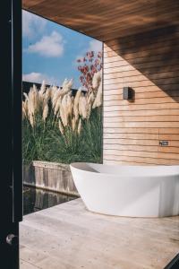 a bath tub sitting on top of a wooden deck at Haven Lake Village in Kortenhoef