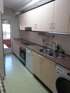 a kitchen with white cabinets and a sink at El pisito de Irene in Béjar