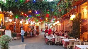 a street with tables and chairs and christmas lights at Sunny studio with Parthenon view balcony in Athens