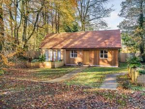 a small wooden house in the middle of a yard at Beech Lodge in Ubley