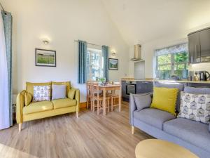 a living room with two couches and a kitchen at Beech Lodge in Ubley