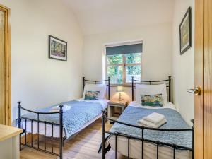 two twin beds in a room with a window at Beech Lodge in Ubley