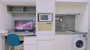 a kitchen with a desk with a computer and a microwave at THE TiME in Incheon