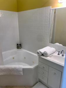 a white bathroom with a tub and a sink at Orange Blossom- Comboyne Mountain Cottages in Comboyne