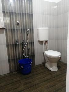 a bathroom with a toilet and a bucket at Tapovan fruitopia in Sultan Bathery