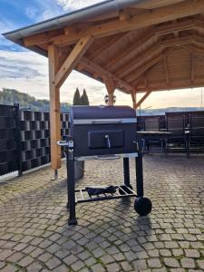 a grill sitting under a pavilion with a roof at ALTES ZOLLHAUS der Burg Hachen 