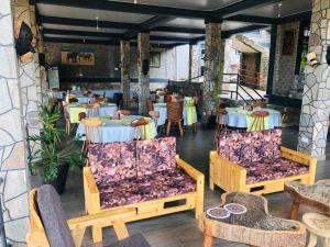 Gipir and Labongo Safari Lodge Ltd في Pakwach East: غرفة طعام بها طاولات وكراسي وطاولة وكراسي