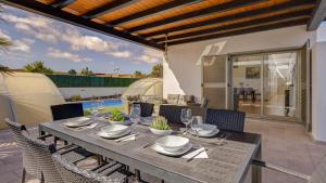 a dining table and chairs on a patio at Villa Melissa in Costa de Antigua