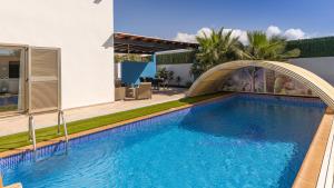 una gran piscina con un arco sobre ella en Villa Melissa, en Costa de Antigua