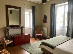 1 dormitorio con cama, espejo y sillas en Maison Castel Braz en Pont-Aven