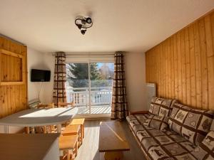 ein Wohnzimmer mit einem Sofa, einem Tisch und einem Fenster in der Unterkunft Boost Your Immo Les Deux Alpes Grande Chaume 173 in Les Deux Alpes