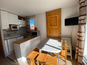 a kitchen with a table and a table and chairs at Boost Your Immo Les Deux Alpes Grande Chaume 173 in Les Deux Alpes