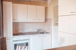 a kitchen with white cabinets and a sink at Gästehaus auf tollem Anwesen in Neubulach