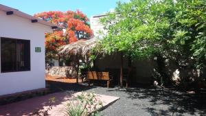 a house with a table and chairs under a tree at Hostal Vista al Mar in Puerto Ayora