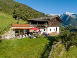 una casa en la ladera de una colina con montañas en Mountain Chalet Obertreyen, en Campo Tures