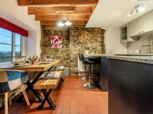 cocina con pared de piedra y mesa de madera en The Annex, en Llanarthney