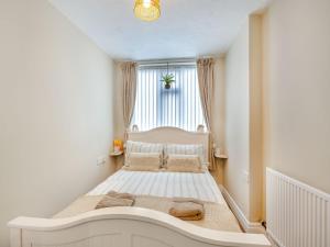 a small bedroom with a bed in front of a window at The Cottage in Rhyl