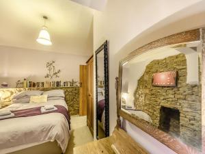 a bedroom with a stone fireplace and a bed at The Annex in Llanarthney