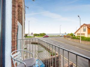 a chair on a balcony with a view of a street at The Cottage in Rhyl