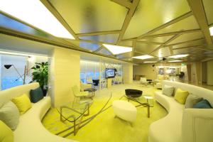 an office lobby with couches and chairs and a television at Beijing Qianyuan Hotel in Beijing