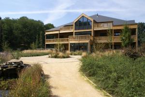 una grande casa con un passaggio di fronte di Recreatiedomein Warredal - The Lodge a Neeroeteren