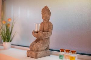 a statue of a person holding a glass on a table at Bungalow im Schwarzwald auf wunderschönem Anwesen in Neubulach