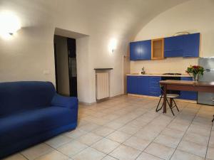 een woonkamer met een blauwe bank en een keuken bij Intero alloggio: appartamento bilocale in Alessandria