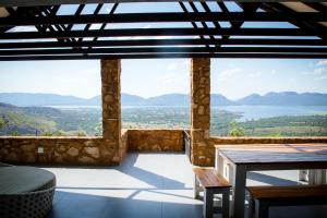a large room with a view of the water and mountains at Rock House at Benlize in Hartbeespoort