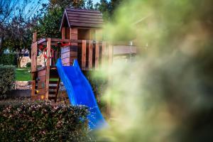 a playground with a blue slide in a yard at Quinta do Esquilo - Hotel Rural in Rendufe