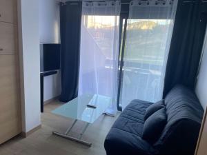 a living room with a couch and a glass table at Superbe studio front de neige la joue du loup in Le Dévoluy +1 photo