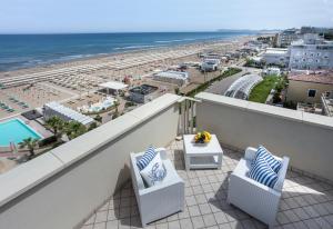 einen Balkon mit 2 Stühlen und Strandblick in der Unterkunft Hotel Admiral - on the beach in Riccione