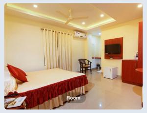 a hotel room with a bed and a tv at Hotel Sasthapuri in Kozhikode