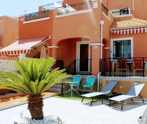 - une vue sur la cour d'une maison avec des chaises et un palmier dans l'établissement Casa Azul, à Alicante