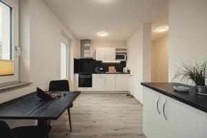 a kitchen with a black counter top and a table at Ferienwohnungen und Boardinghouse Heimbach in Renchen in Renchen