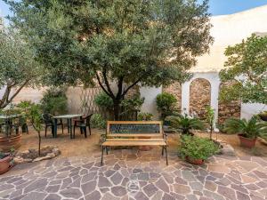 un banco en un jardín con una mesa y un árbol en Val Paraiso Rooms - Unforgettable Holiday, en Teulada