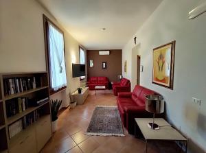 a living room with a red couch and a table at Domus San Bernardino in Verona